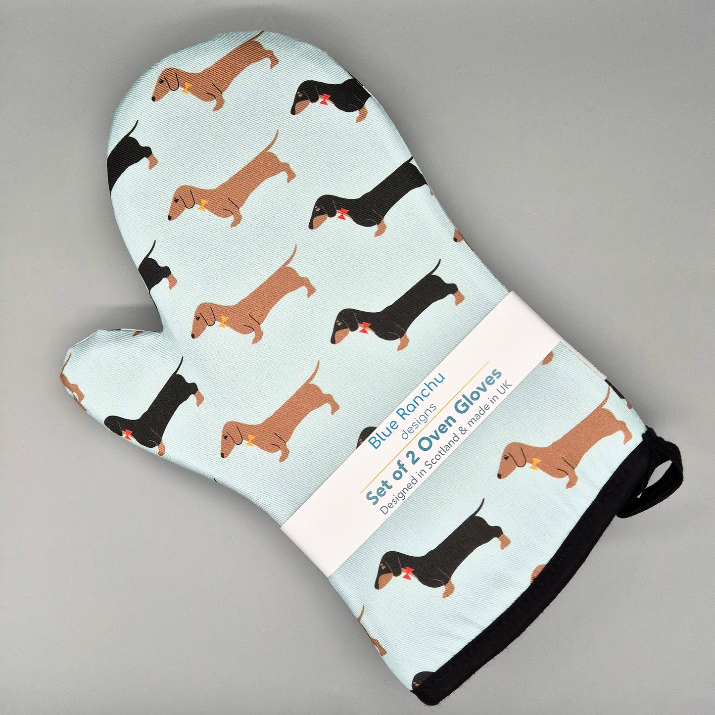 Oven mitts with dachshund pattern on a light green background