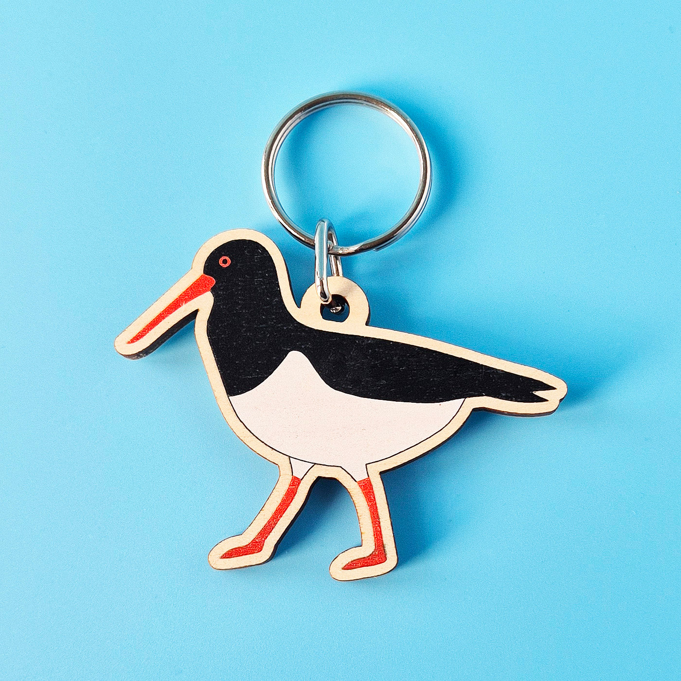 Oystercatcher shaped keyring on a blue background