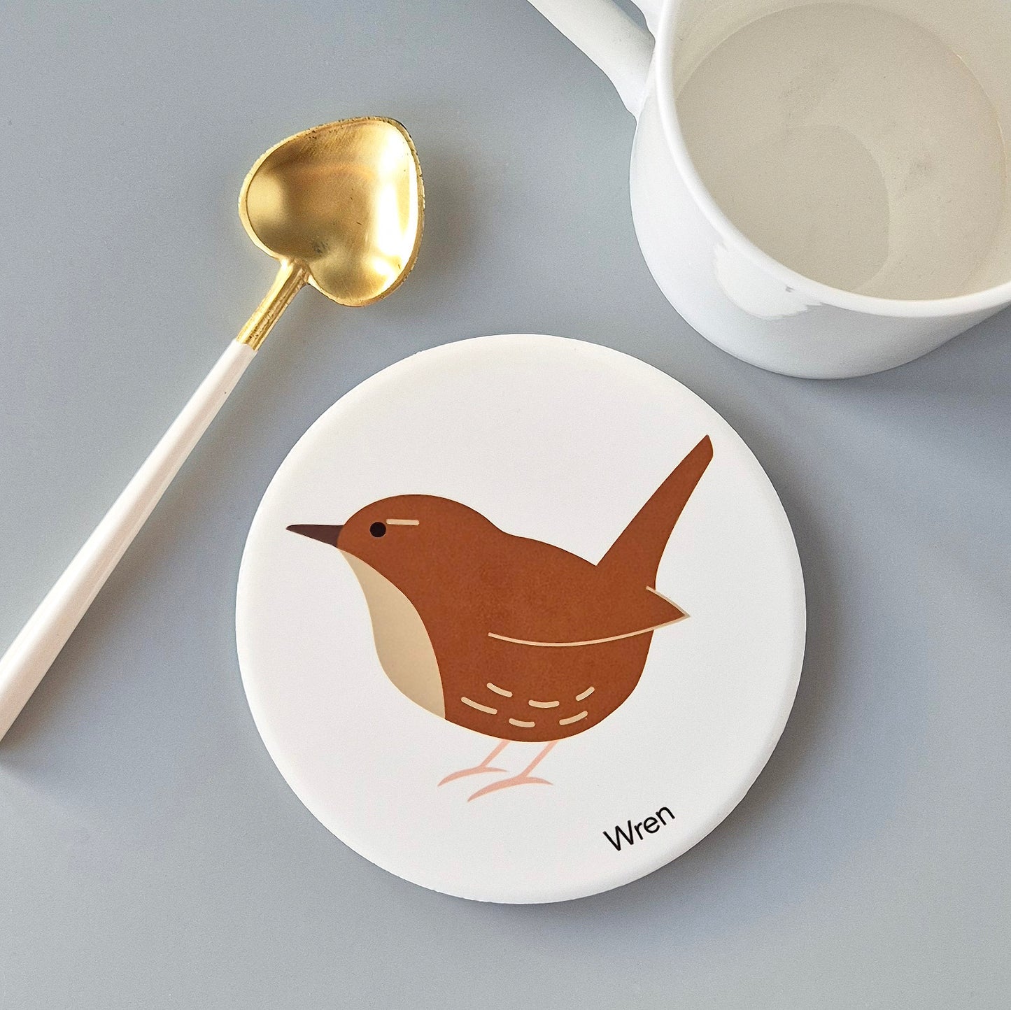 Round white ceramic coaster with a Wren design