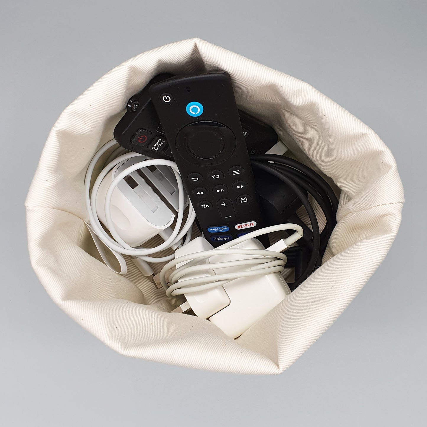 Cats fabric storage basket shown storing chargers and remote controls