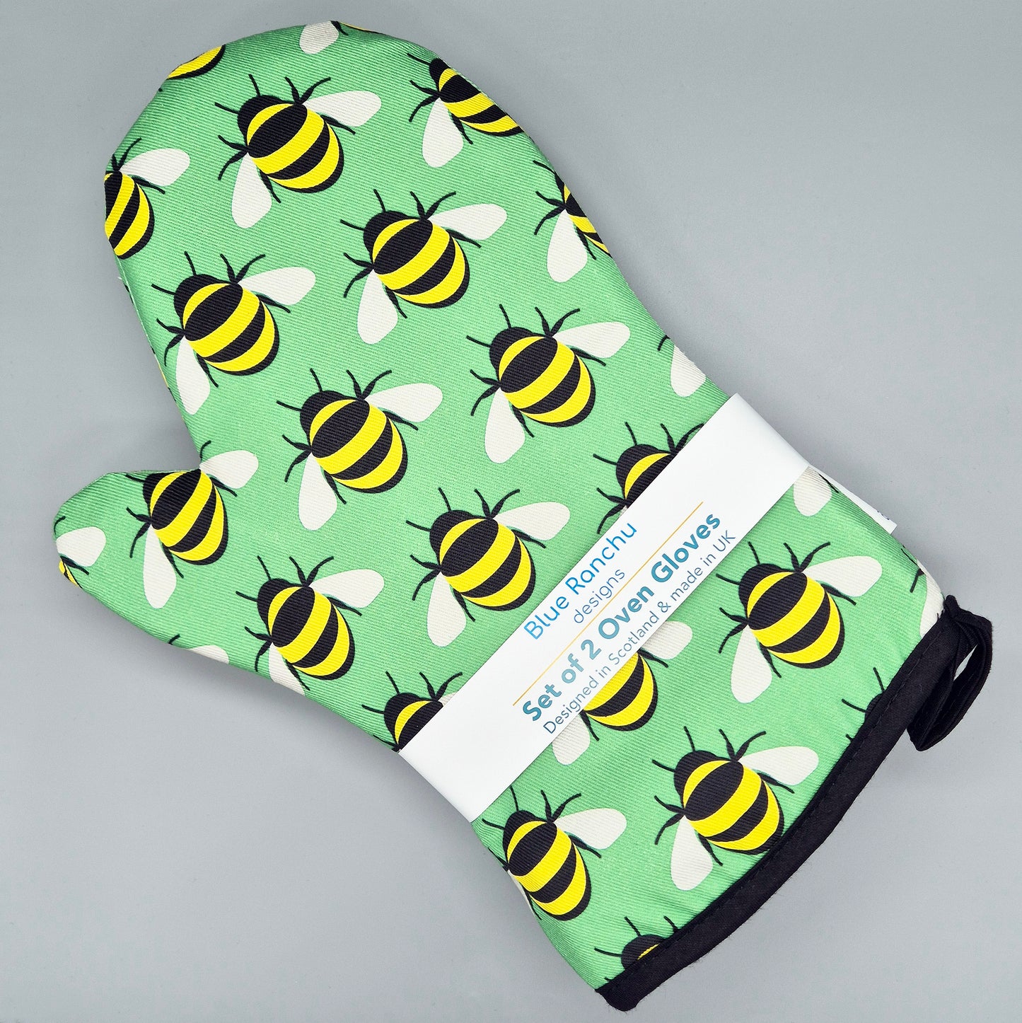Oven gloves with bee pattern on a green background, featuring Blue Rancho branding.