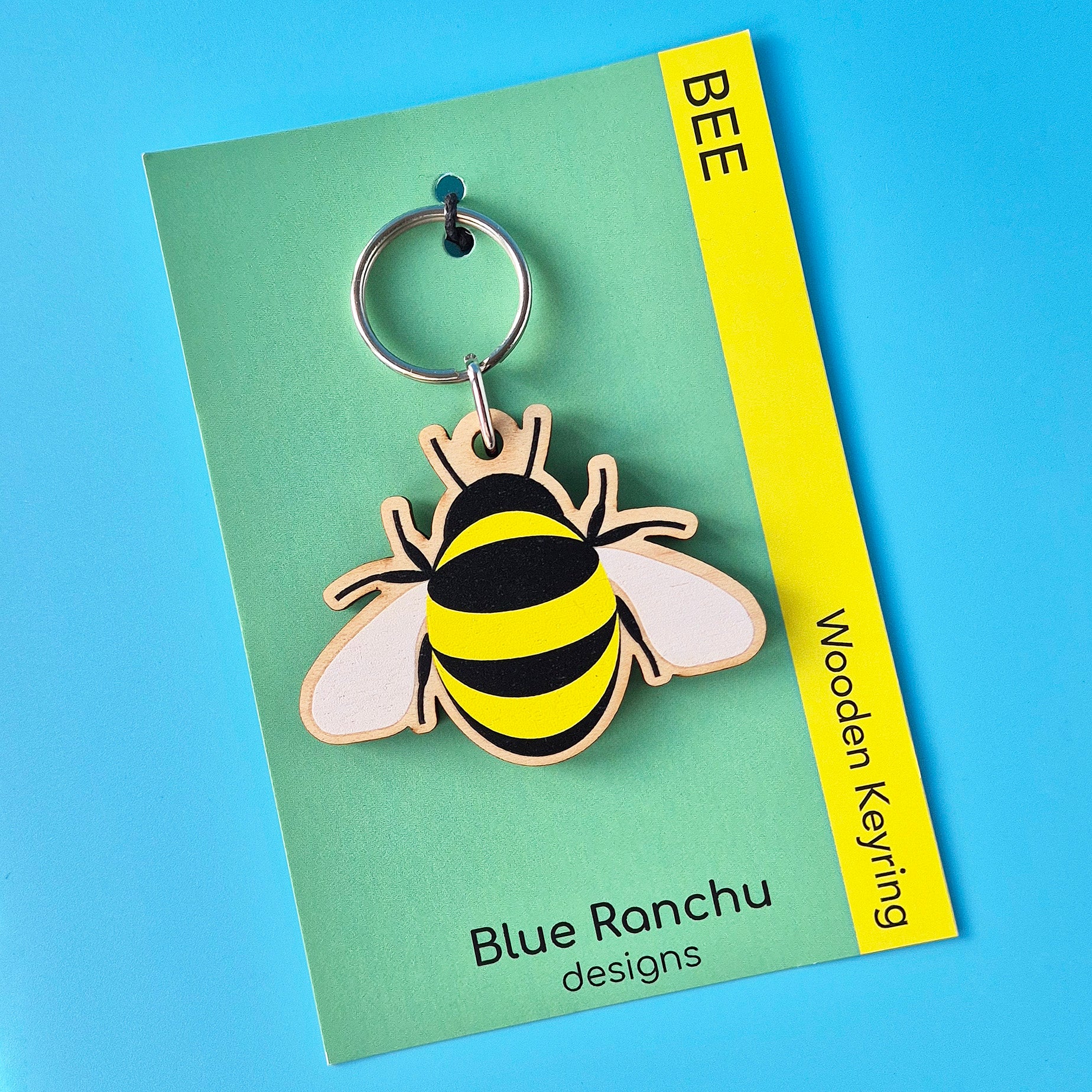 Bee-shaped wooden keyring on a Blue Ranchu designs card with a blue background