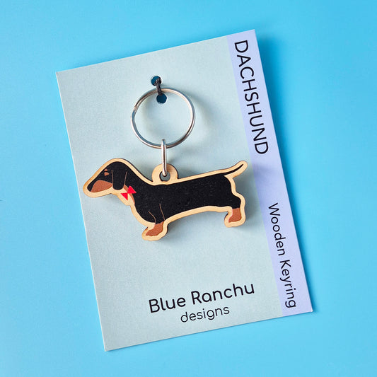 Black and Tan Dachshund shaped wooden keyring on a backing card