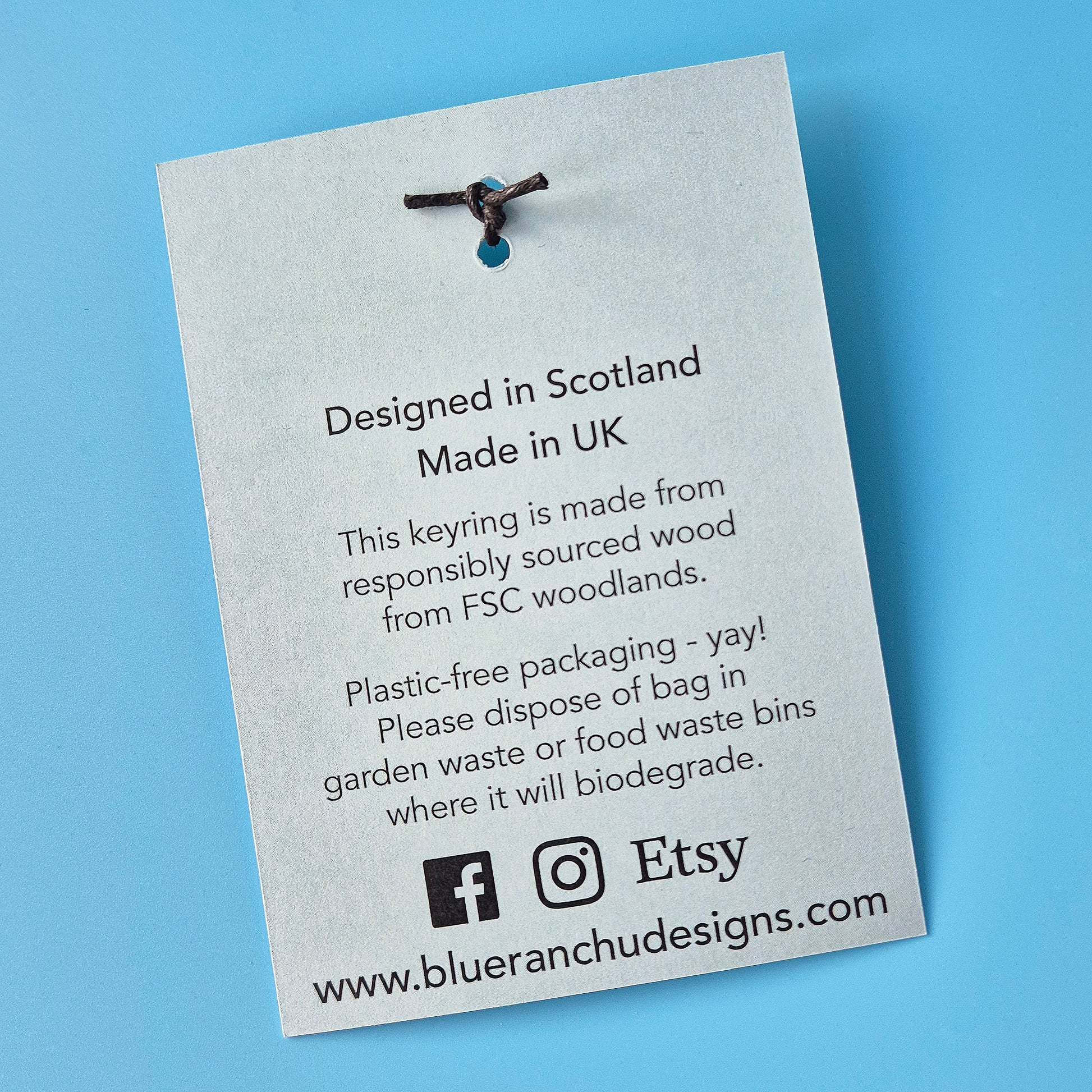 Keyring on a card with text about its origin and sustainability on a blue background