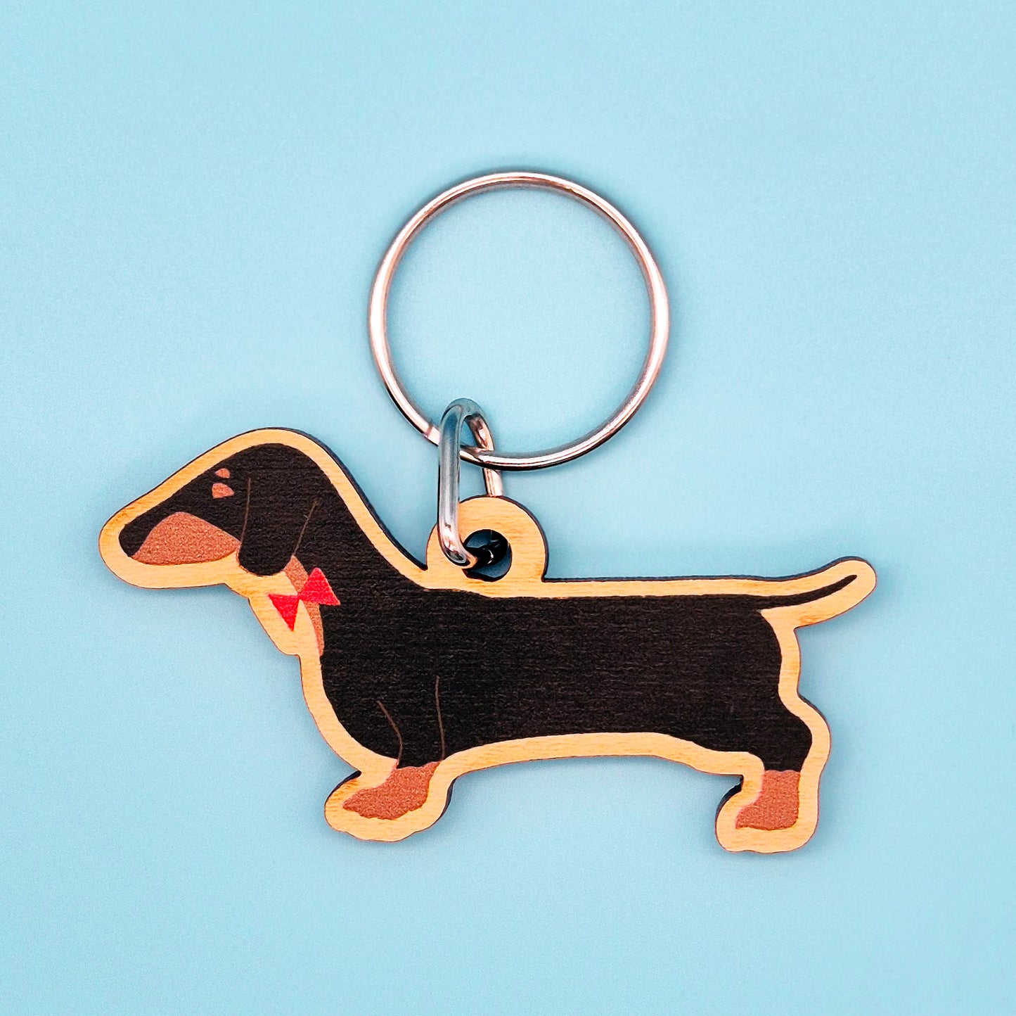 Sausage dog-shaped keychain on a light blue background