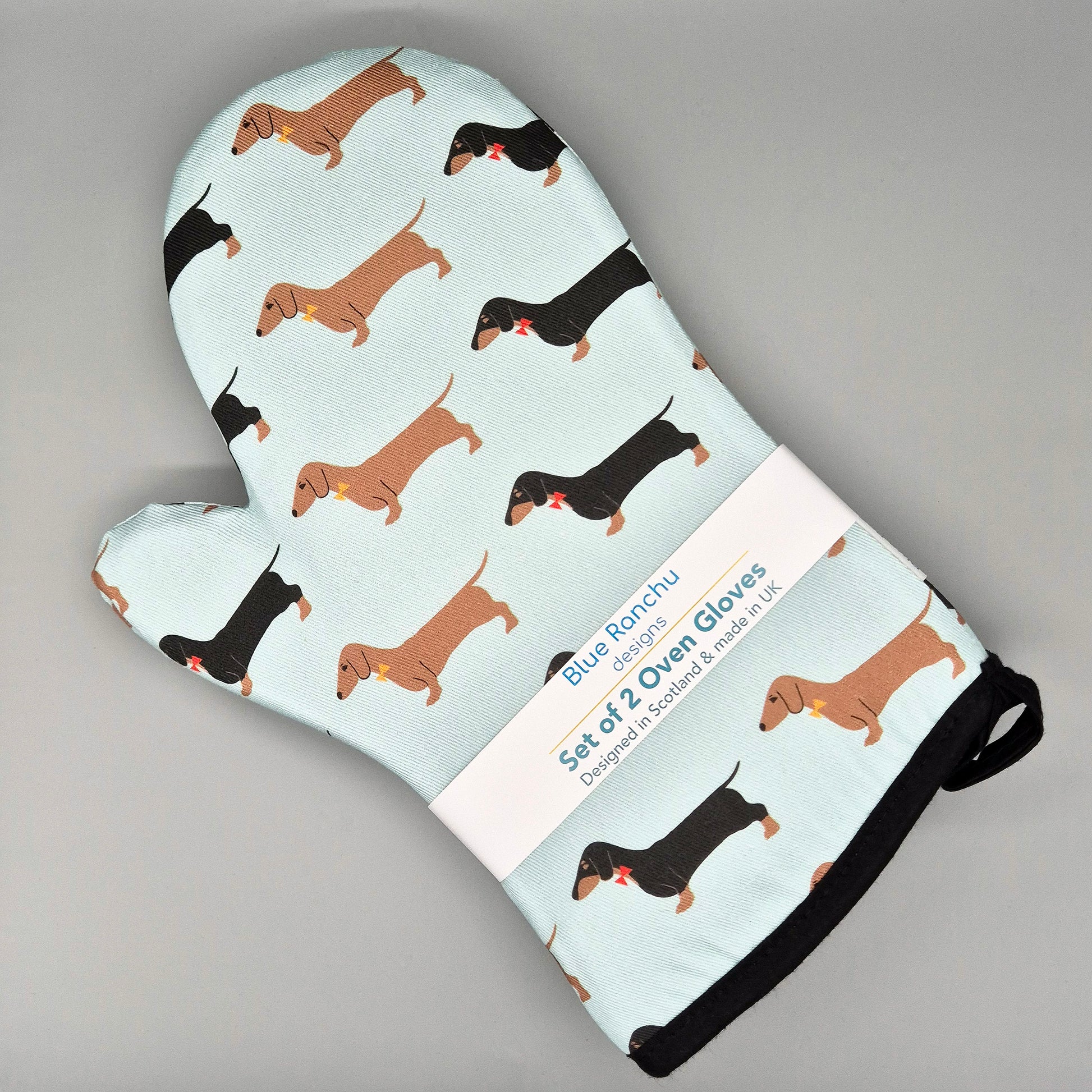 Oven mitts with dachshund pattern on a light green background