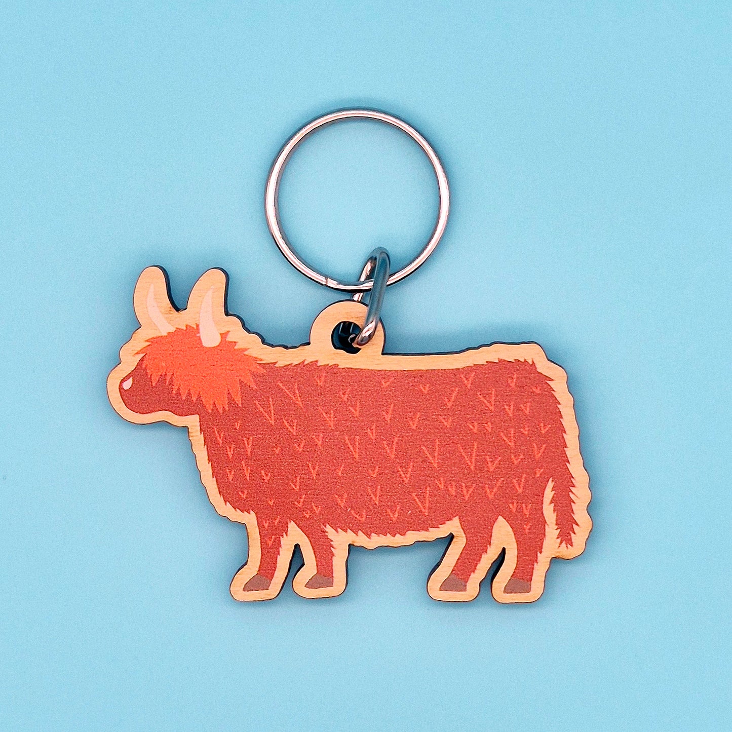 Keyring shaped like a Highland Cow on a blue background
