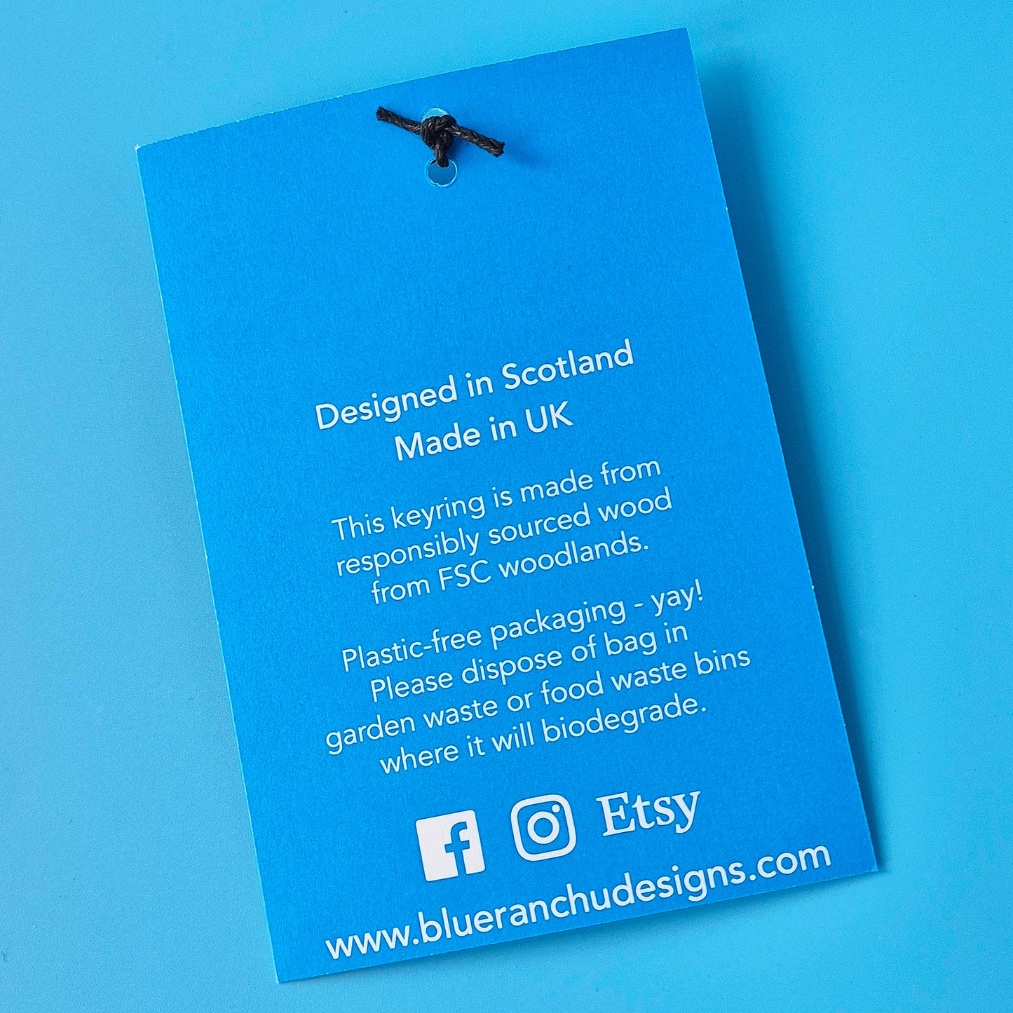 Orca keyring with text about product origin and sustainability on a blue background