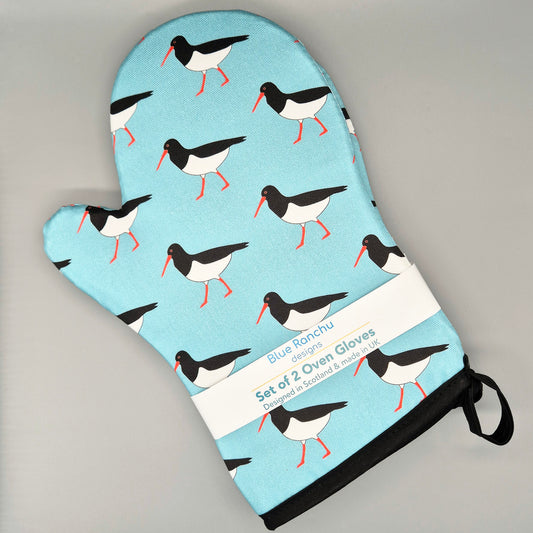 Set of 2 Oystercatcher oven mitts with bird pattern on a light blue background