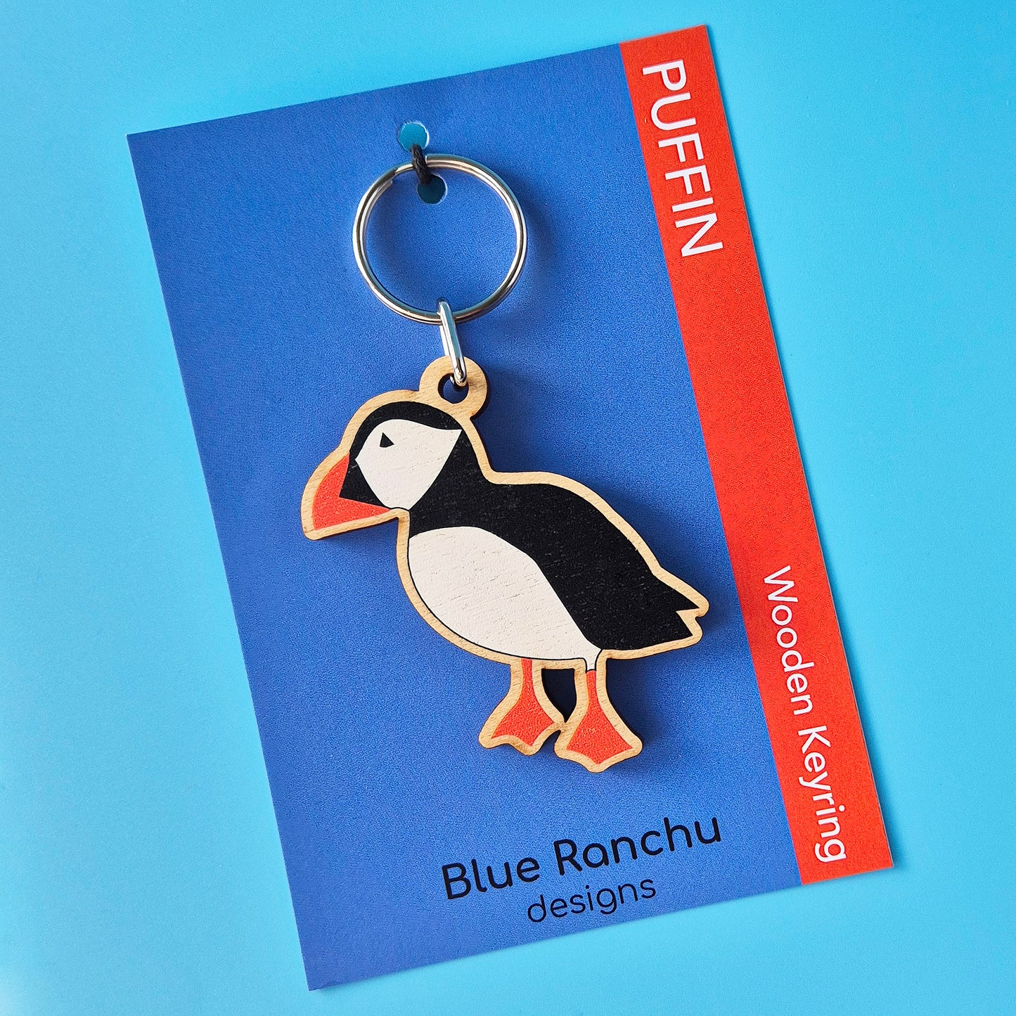 Puffin-shaped wooden keyring on a Blue Ranchu designs card with a blue background