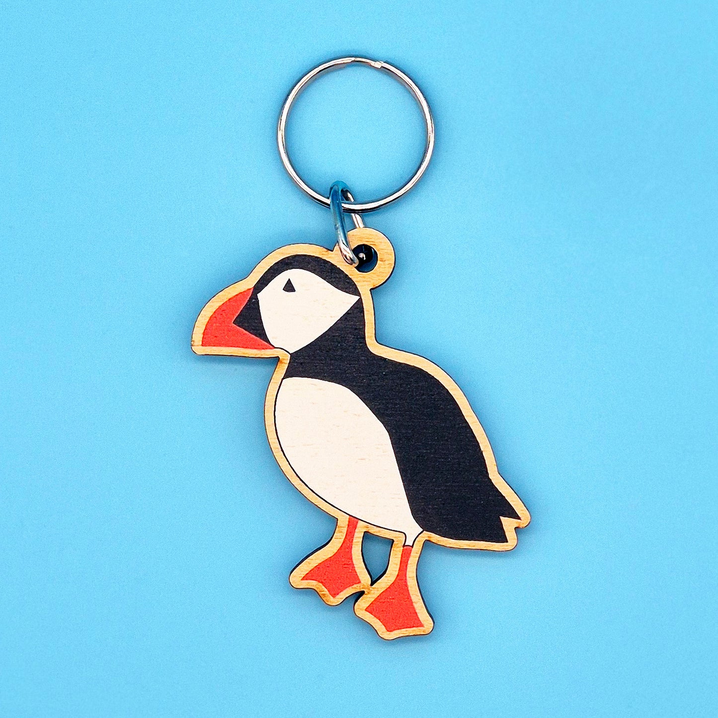 Puffin-shaped keychain on a blue background