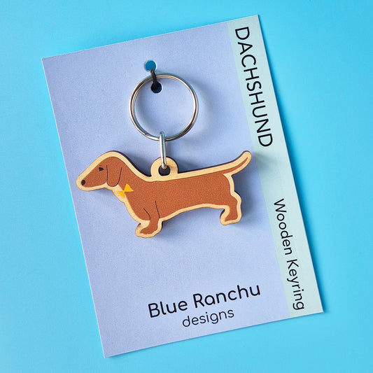 Red smooth haired Dachshund-shaped wooden keychain on a Blue Ranchu designs card with a blue background
