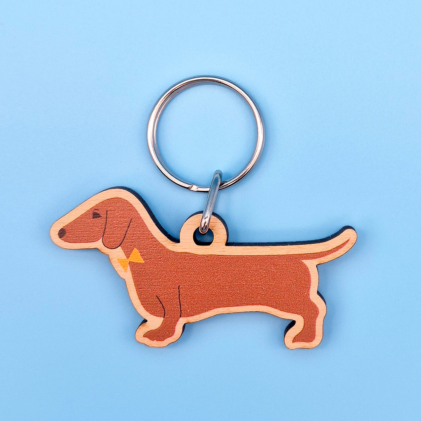 Sausage dog-shaped keychain on a blue background