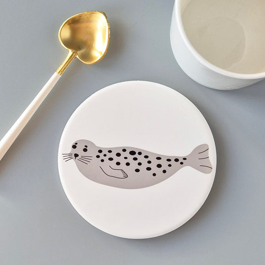 Seal design on a white round ceramic coaster