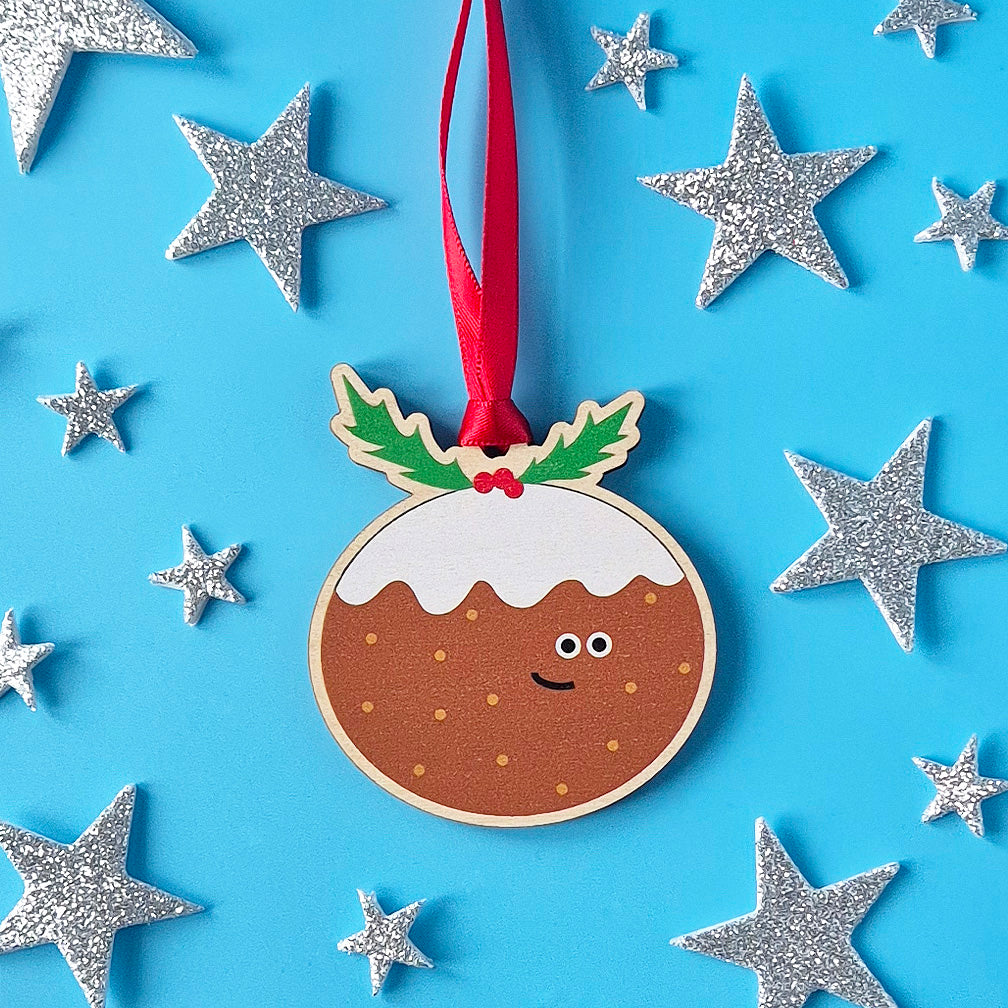Smiling Christmas pudding wooden decoration surrounded by shining silver stars